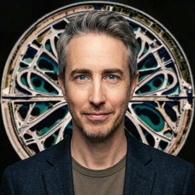Portrait of Ryan Kelln in front of a circular aerial map artwork from Experimance